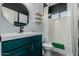 Stylish bathroom features modern wallpaper, teal vanity with gold fixtures, and tub/shower combo at 7204 S Golfside Ln, Phoenix, AZ 85042
