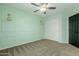 Light green bedroom with a ceiling fan, built in wall decor, and carpeted floors at 7204 S Golfside Ln, Phoenix, AZ 85042
