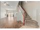 Bright, open-concept living space featuring hardwood floors, neutral walls, and a staircase with carpeted steps and a wooden banister at 7204 S Golfside Ln, Phoenix, AZ 85042