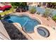 Aerial view of the sparkling pool, spa, and meticulously landscaped backyard at 7242 W Aurora Dr, Glendale, AZ 85308