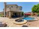 Spacious backyard featuring a pool, spa, covered patio, and lush landscaping, perfect for outdoor enjoyment at 7242 W Aurora Dr, Glendale, AZ 85308