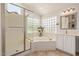 Bright bathroom with tub, shower, and dual sinks at 7242 W Aurora Dr, Glendale, AZ 85308