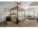 Spacious main bedroom with four poster bed and sitting area at 7242 W Aurora Dr, Glendale, AZ 85308