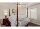 Bedroom with a four-poster bed, ceiling fan, and shuttered windows for a bright and airy feel at 7242 W Aurora Dr, Glendale, AZ 85308