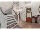 Bright foyer with winding staircase, tile floors and stylish decorations at 7242 W Aurora Dr, Glendale, AZ 85308
