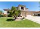 Inviting home featuring a manicured lawn, desert landscaping and a three car garage at 7242 W Aurora Dr, Glendale, AZ 85308