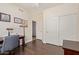 Home office area with dark wood flooring, a large desk, and closet space at 7242 W Aurora Dr, Glendale, AZ 85308