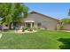 Picturesque backyard with a water feature, lush grass, and a variety of mature trees and desert plants at 7508 E Aster Dr, Scottsdale, AZ 85260