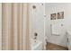 Bright bathroom featuring marble-style tile, a shower-tub combo, and neutral color palette at 7508 E Aster Dr, Scottsdale, AZ 85260