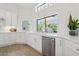Bright white kitchen featuring stainless steel appliances and a window overlooking the backyard at 7508 E Aster Dr, Scottsdale, AZ 85260