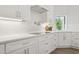 Clean white kitchen with subway tile backsplash, modern fixtures, and wood-look tile flooring at 7508 E Aster Dr, Scottsdale, AZ 85260