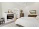 Beautiful main bedroom featuring a fireplace, ensuite bathroom, neutral decor, and light hardwood floors at 7508 E Aster Dr, Scottsdale, AZ 85260