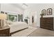 Bright main bedroom featuring a fireplace, wood floors, neutral decor, and a door to the backyard at 7508 E Aster Dr, Scottsdale, AZ 85260