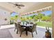 Covered patio featuring an outdoor dining table with seating, overlooking the backyard pool and lush landscaping at 7508 E Aster Dr, Scottsdale, AZ 85260