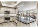Bright, open kitchen with stainless steel appliances, stone countertops, and view of living area at 7601 E Indian Bend Rd # 3002, Scottsdale, AZ 85250