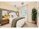 Stylish bedroom with a decorative headboard, patterned accent wall, and lots of natural light at 8149 E Petunia Ave # 1013, Mesa, AZ 85212