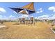 Community playground featuring climbing equipment, play structures, and shade sails for sun protection at 8149 E Petunia Ave # 1013, Mesa, AZ 85212