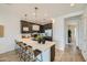 Spacious kitchen with barstool seating, dark cabinets, stainless appliances and decorative pendant lights for a modern aesthetic at 8149 E Petunia Ave # 1013, Mesa, AZ 85212