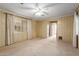 Open bedroom with a ceiling fan, tan carpet, and a light-filled window at 8337 E Desert Trl, Mesa, AZ 85208