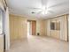 Bright bedroom featuring a ceiling fan, tan carpet, and access door at 8337 E Desert Trl, Mesa, AZ 85208