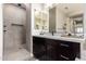 Sleek bathroom features dual mirrors, quartz countertops, dark wood cabinetry, and walk-in shower at 9281 W Villa Chula --, Peoria, AZ 85383