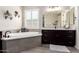 Modern bathroom features a soaking tub with tile surround, dark wood cabinets, and plantation shutters at 9281 W Villa Chula --, Peoria, AZ 85383