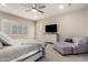 Bright bedroom features plantation shutters, ceiling fan, dresser with television, and comfy lounge chair at 9281 W Villa Chula --, Peoria, AZ 85383