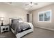 Neutral bedroom featuring soft carpet, plantation shutters, and a comfortable bed with gray bedding at 9281 W Villa Chula --, Peoria, AZ 85383