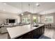 Modern kitchen featuring dark cabinets, a white countertop island, and seamless flow to living and dining areas at 9281 W Villa Chula --, Peoria, AZ 85383