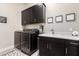 Well-equipped laundry room with modern appliances, dark cabinets, and attractive decor at 9281 W Villa Chula --, Peoria, AZ 85383