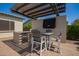 Outdoor kitchen with stainless steel appliances, a built-in grill, a covered dining area, and ambient lighting at 9281 W Villa Chula --, Peoria, AZ 85383