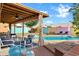 Inviting backyard space with a covered patio, comfortable seating, pool, and well-manicured landscaping at 1215 W Wahalla W Ln, Phoenix, AZ 85027