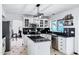 Bright kitchen featuring white cabinets, stainless steel appliances, black countertops, island, and modern pendant lighting at 1215 W Wahalla W Ln, Phoenix, AZ 85027