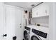 Convenient laundry room with modern washer and dryer, ample storage cabinets, and direct access to the garage at 1215 W Wahalla W Ln, Phoenix, AZ 85027