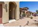 Covered front entry way features clay tile roof, desert landscaping, and two chairs for sitting at 14208 W Larkspur Dr, Surprise, AZ 85379