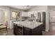 Modern kitchen boasts an island with wine cooler, stainless steel appliances, and chic backsplash at 14208 W Larkspur Dr, Surprise, AZ 85379