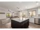 Stylish open-concept kitchen features an island with seating and stainless steel appliances at 14208 W Larkspur Dr, Surprise, AZ 85379