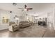 A spacious living room with lots of light features modern decor, wood floors, and access to the kitchen at 14208 W Larkspur Dr, Surprise, AZ 85379