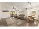 Open-concept living room features a cozy seating area, wood floors, and sliding glass doors to the backyard at 14208 W Larkspur Dr, Surprise, AZ 85379