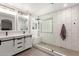 Modern main bathroom with double vanity, large, tiled shower with bench, and glass enclosure at 14208 W Larkspur Dr, Surprise, AZ 85379