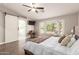 Spacious main bedroom features a ceiling fan, bay window, and an en-suite bathroom with sliding barn door at 14208 W Larkspur Dr, Surprise, AZ 85379