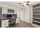 Office space with wood floor, built-in cabinets and shelving, light-tone walls, and ceiling fan at 14208 W Larkspur Dr, Surprise, AZ 85379