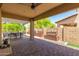 Outdoor patio area under a pergola, with seating, grilling area, and pavers at 14208 W Larkspur Dr, Surprise, AZ 85379