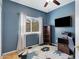 Stylish bedroom with hardwood floors, a modern rug, TV, and a blue accent wall for a contemporary, comfortable feel at 14801 S 8Th St, Phoenix, AZ 85048