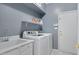 Functional laundry room with modern washer and dryer, sink, and ample shelving for organized storage and efficient laundry at 14801 S 8Th St, Phoenix, AZ 85048