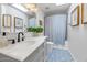 Bright bathroom featuring patterned tile floors, modern vanity, vessel sink, skylight, and a shower-tub combination at 15020 S 25Th St, Phoenix, AZ 85048