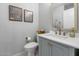 Stylish powder room featuring a gray vanity, modern fixtures, and framed floral prints at 15020 S 25Th St, Phoenix, AZ 85048