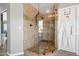 Elegant walk-in shower with decorative tile work and glass enclosure, adjacent to a white waffle robe at 15020 S 25Th St, Phoenix, AZ 85048