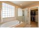 Spa-like bathroom with a soaking tub, a glass-enclosed shower, and a view into the walk-in closet at 15107 E Desert Willow Dr, Fountain Hills, AZ 85268