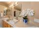 Elegant bathroom with dual sinks, granite countertops, modern faucets, and decorative floral arrangement at 15107 E Desert Willow Dr, Fountain Hills, AZ 85268